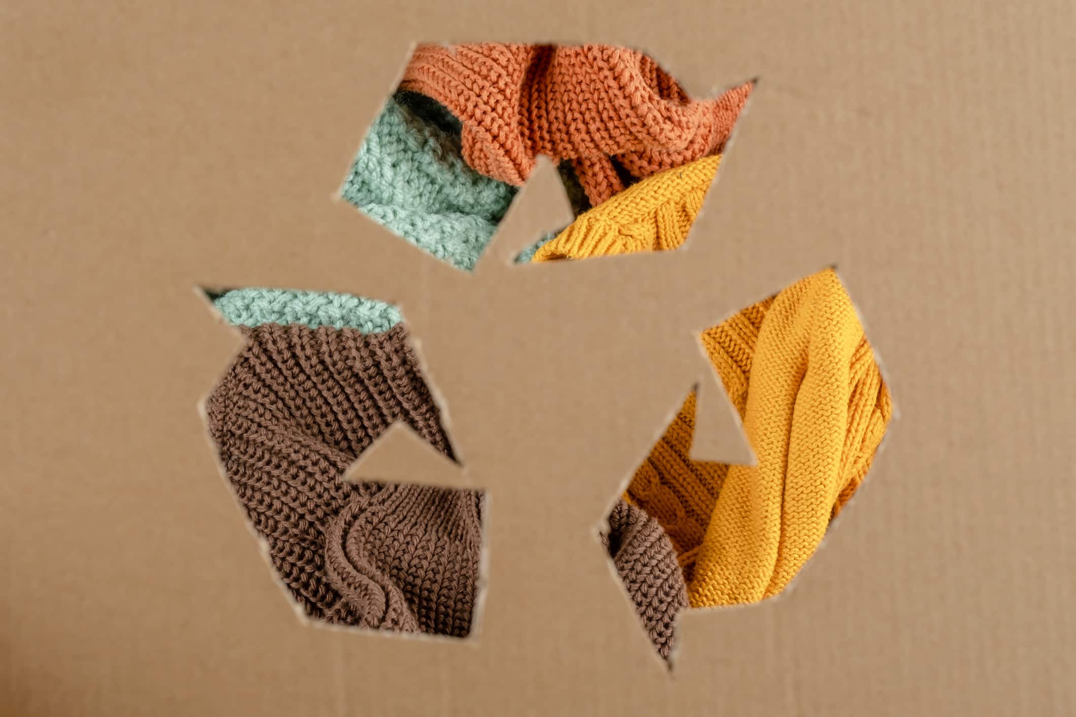 Recycling sign on cardboard paper on clothing background